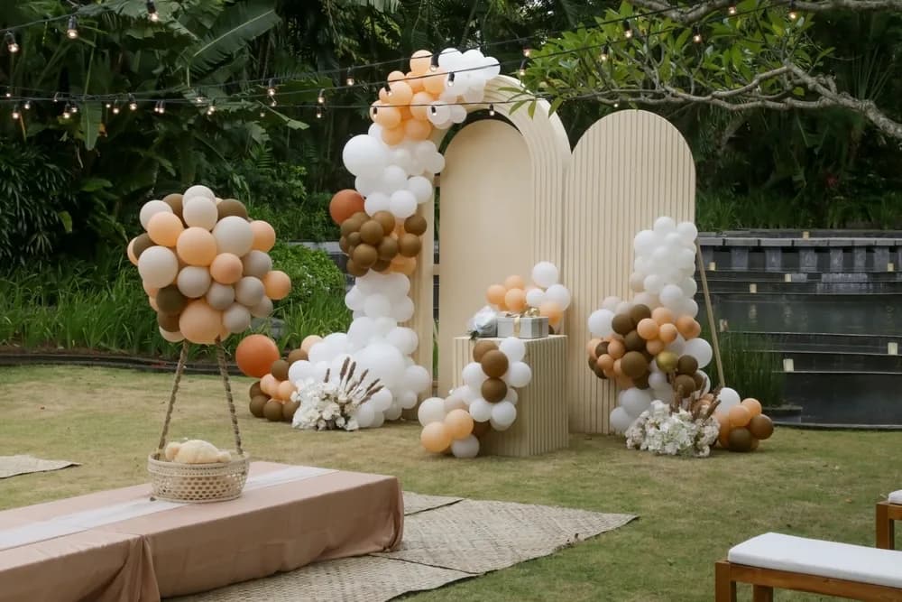 Installation boho en extérieur avec arche de ballons et panneaux