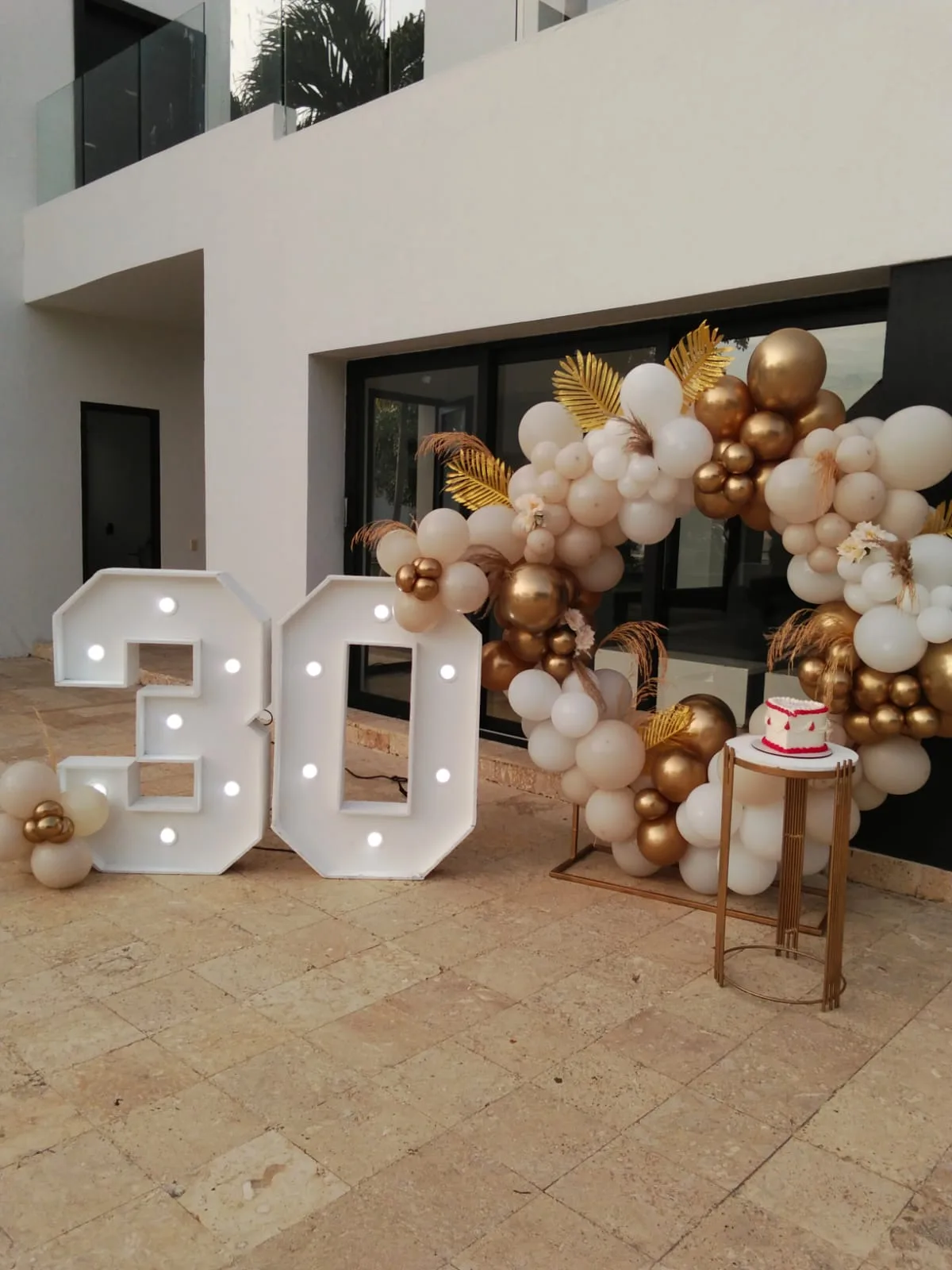 Chiffre 30 lumineux et arche de ballons blanc et or en extérieur